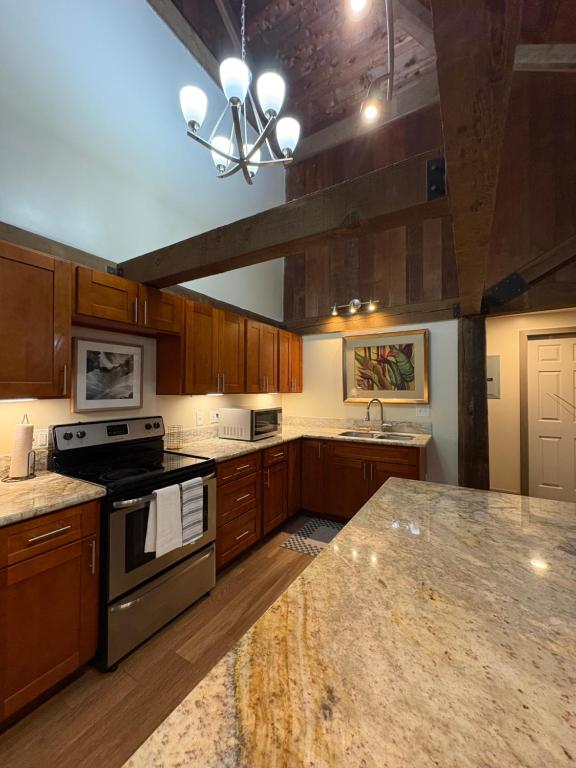 a large kitchen with wooden cabinets and a stove top oven at Kaena O Kekai in Hauula