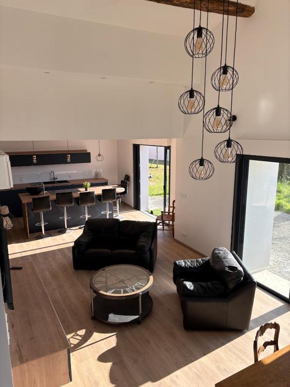 a living room with black couches and a table at La Claverie in Cholet