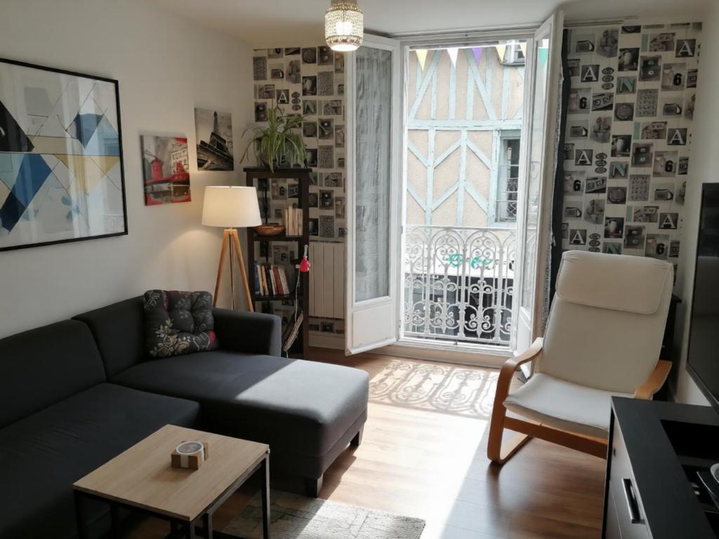 a living room with a couch and a chair and a window at Spacieux T3 lumineux dans quartier historique avec wifi in Redon