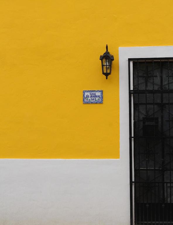a yellow and white wall with a light on it at House with pool in downtown Merida, Yucatan in Mérida