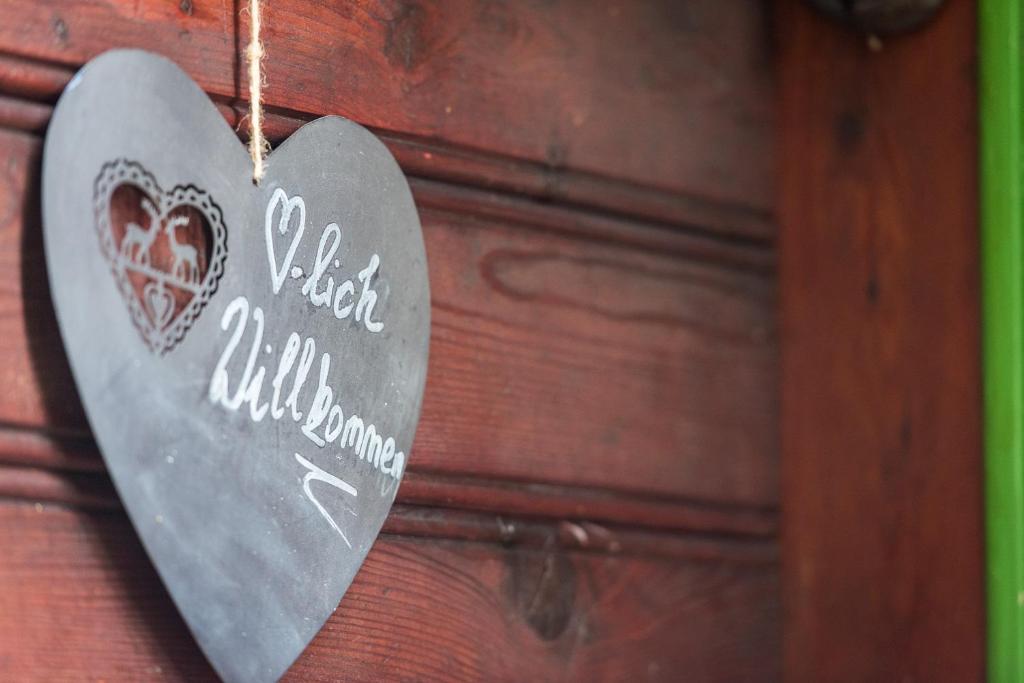 un corazón de metal colgando de una pared de madera en Waldhütte, en Hochpillberg