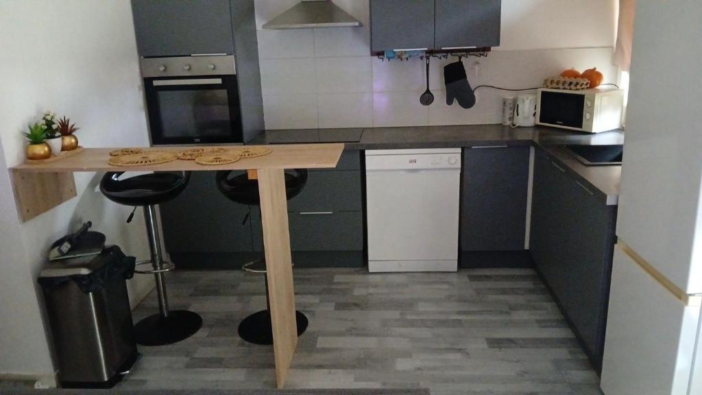 a small kitchen with a wooden table in it at 2 Chambres, 4 personnes, jardin, proche centre ville in Perpignan