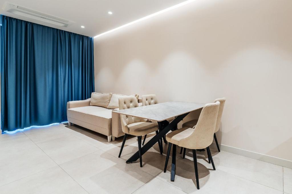 a dining room with a table and chairs and a couch at Coastal Residences by In Property in Bečići