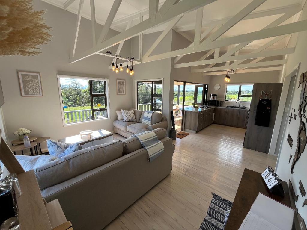 a living room with a couch and a table at Elephant View Homestead - Hydrangea Cottage in Plettenberg Bay