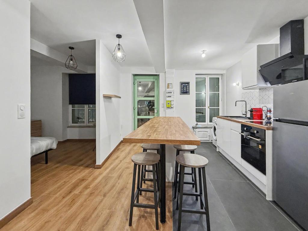 a kitchen with a counter and stools in it at Le Vercors in Valence