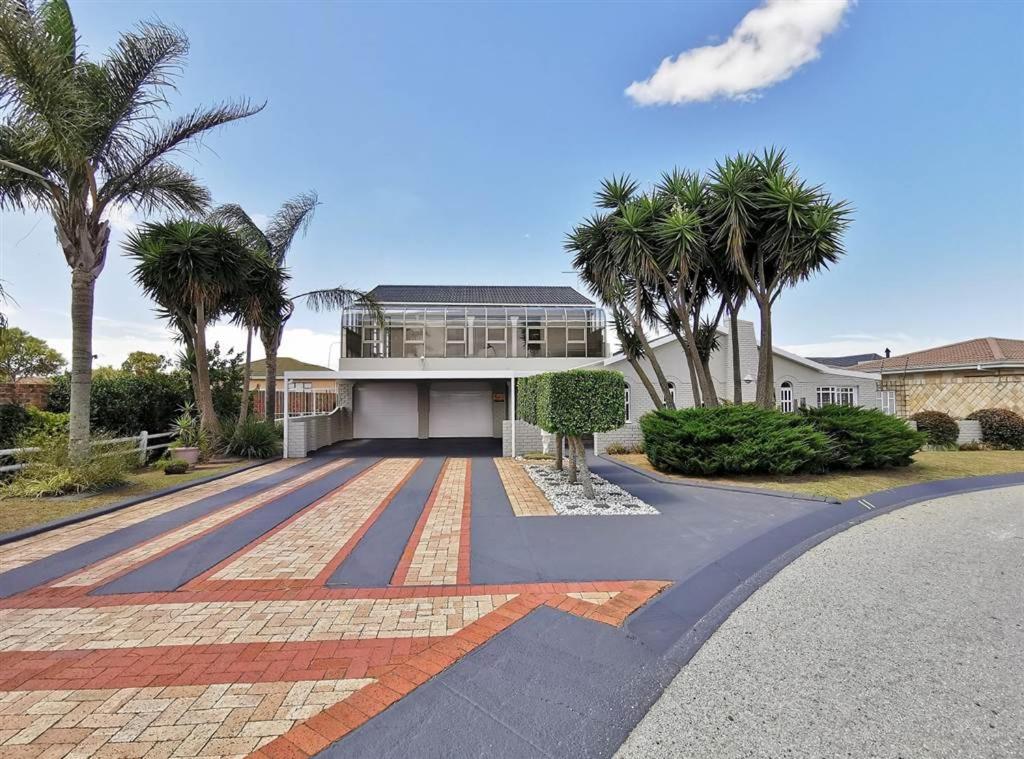 a house with palm trees in front of it at Khans Residence in Gqeberha