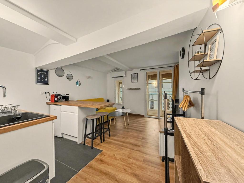 a kitchen and living room with a counter and chairs at Sous Les Toits in Valence