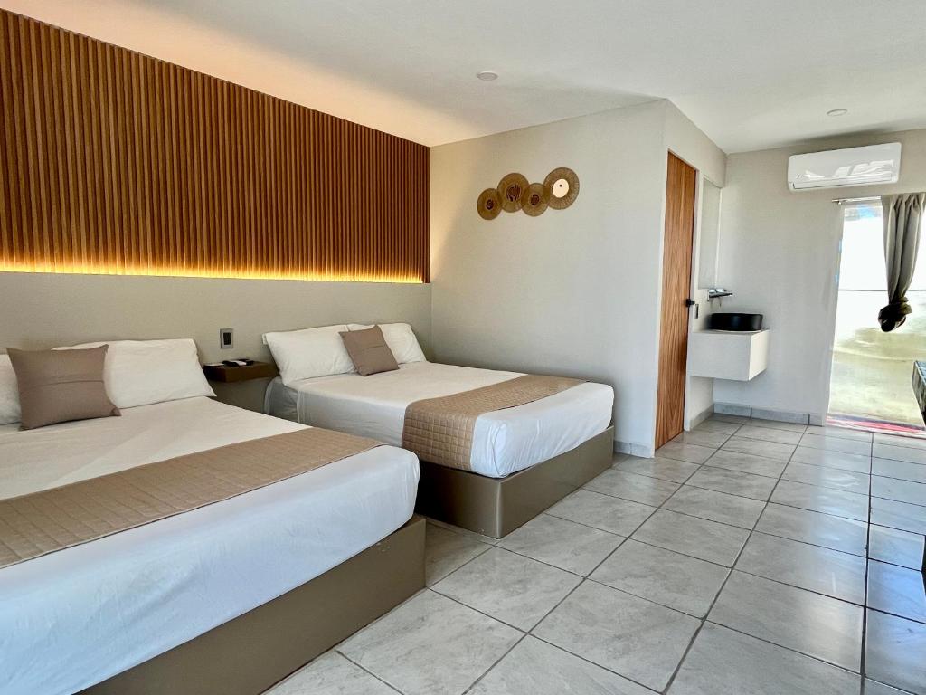 a hotel room with two beds and a television at Hotel Mare in Santa Maria Huatulco