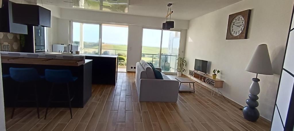 a living room with a kitchen and a living room with a table at Appartement face golf et océan in Saint-Jean-de-Monts