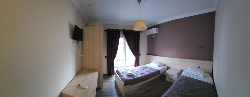 a room with two beds and a window at JULI Veal in Tepelenë
