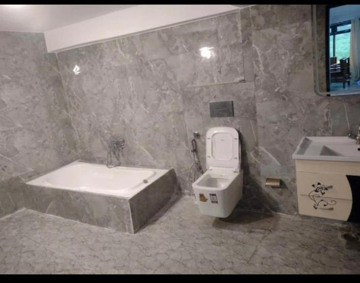 a bathroom with a tub and a toilet and a sink at Hotel shree ji in Lucknow