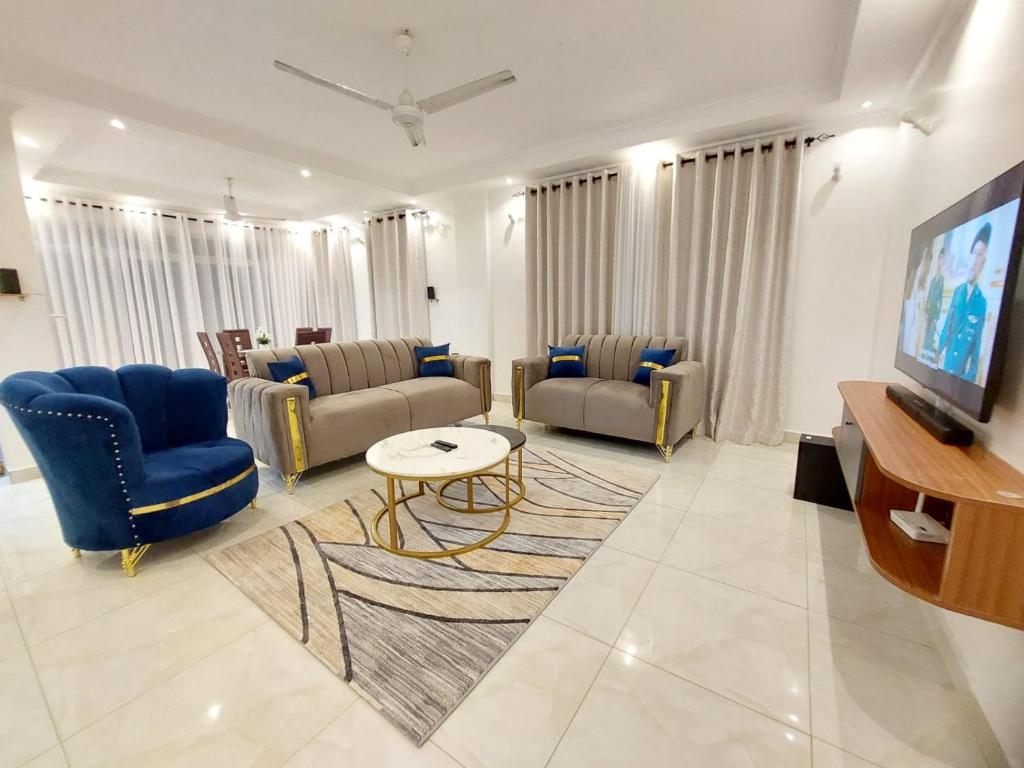 a living room with two couches and a tv at Laxury3BR Mins to Nyali Beach fast WiFi Netflix AC and Free Parking Near wild waters in Mombasa