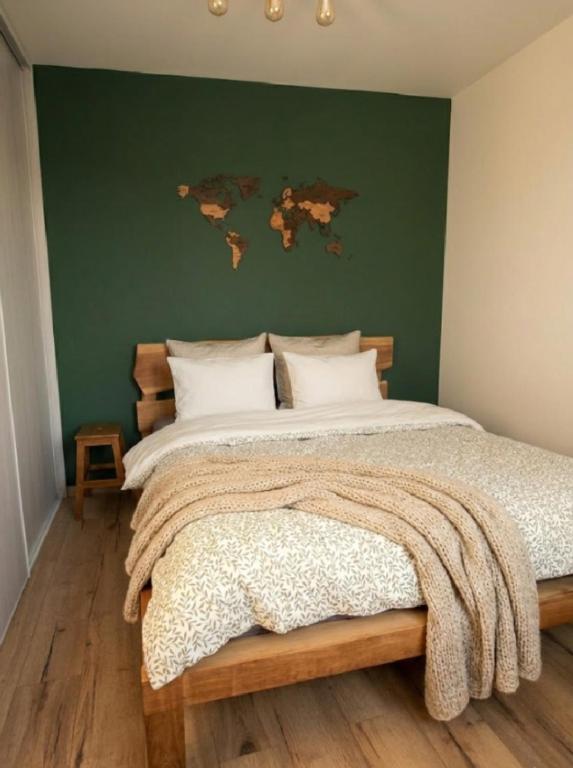 a bedroom with a large bed with a green wall at Apartament na Bora in Tarnów