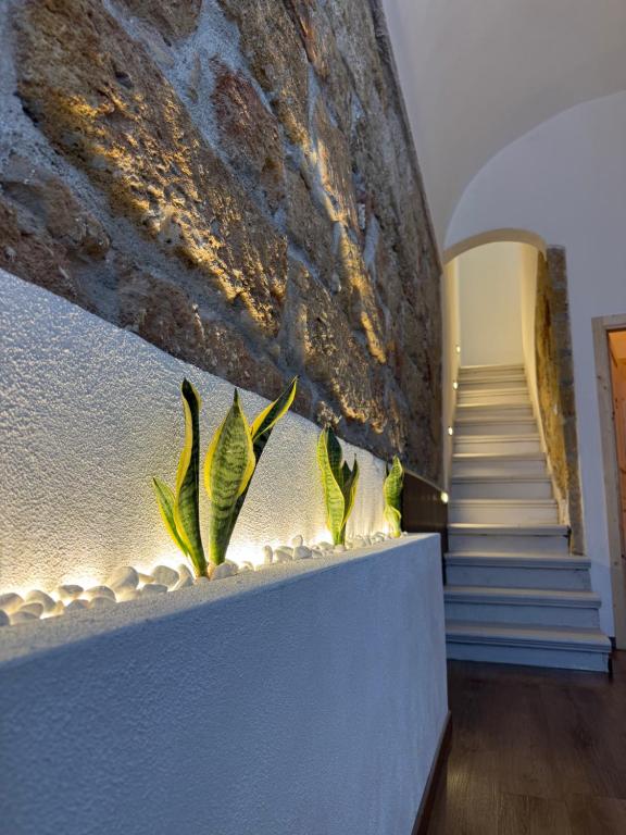 a staircase in a building with a stone wall at Bella Gallery Terrasini in Terrasini