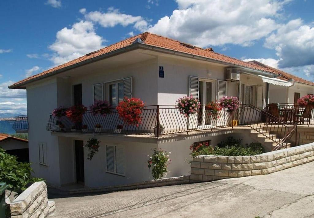 a white house with flowers on the balcony at Apartment Pavin in Poljana
