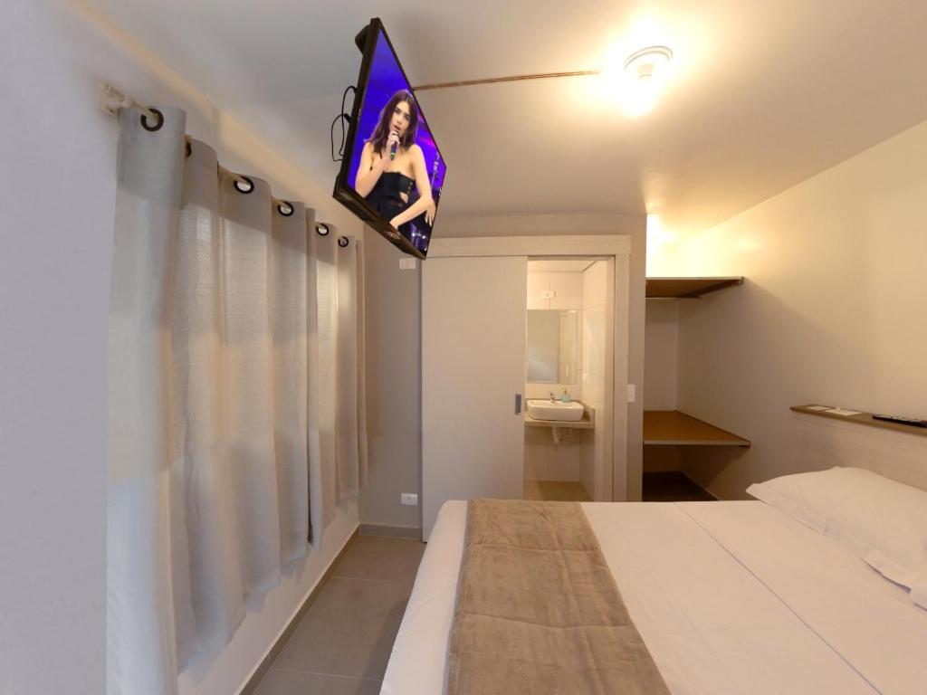 a room with a bed with a vanity and a window at Pousada BRAWAY in Curitiba