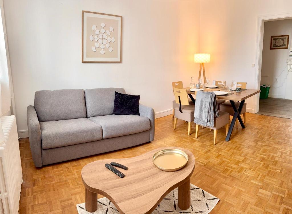 a living room with a couch and a table at Le Carré Chic in Limoges