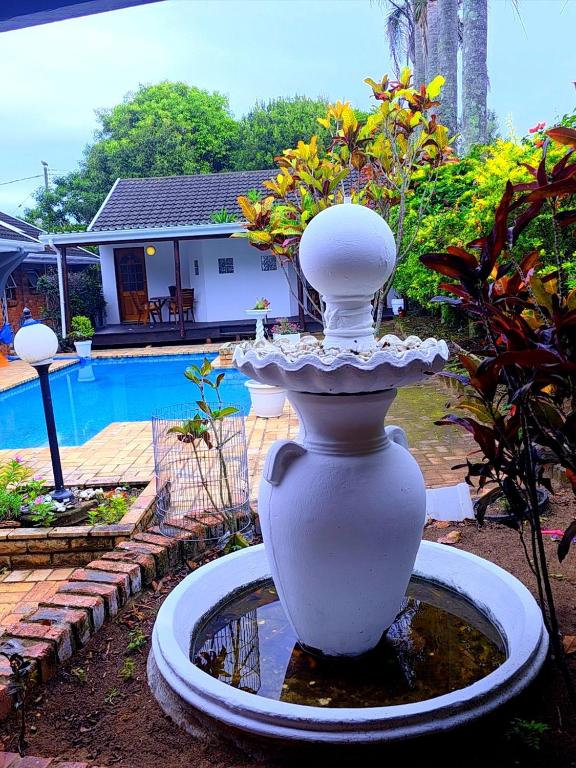 a large white vase sitting in front of a pool at Blue Bend Valley in East London