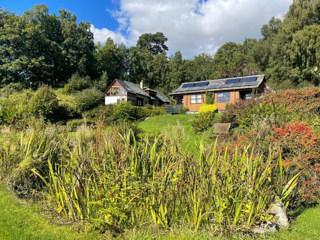 a house with solar panels on top of a garden at Morenish Estate in Killin