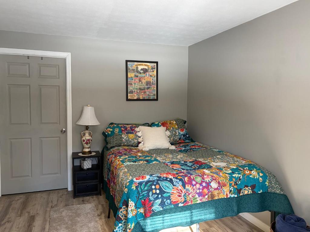 a bedroom with a bed with a colorful comforter at Crawford Suite in Meadville