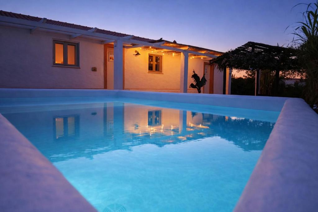a swimming pool in front of a house at night at Monte da Rocha 3 Marias in São Bartolomeu da Serra