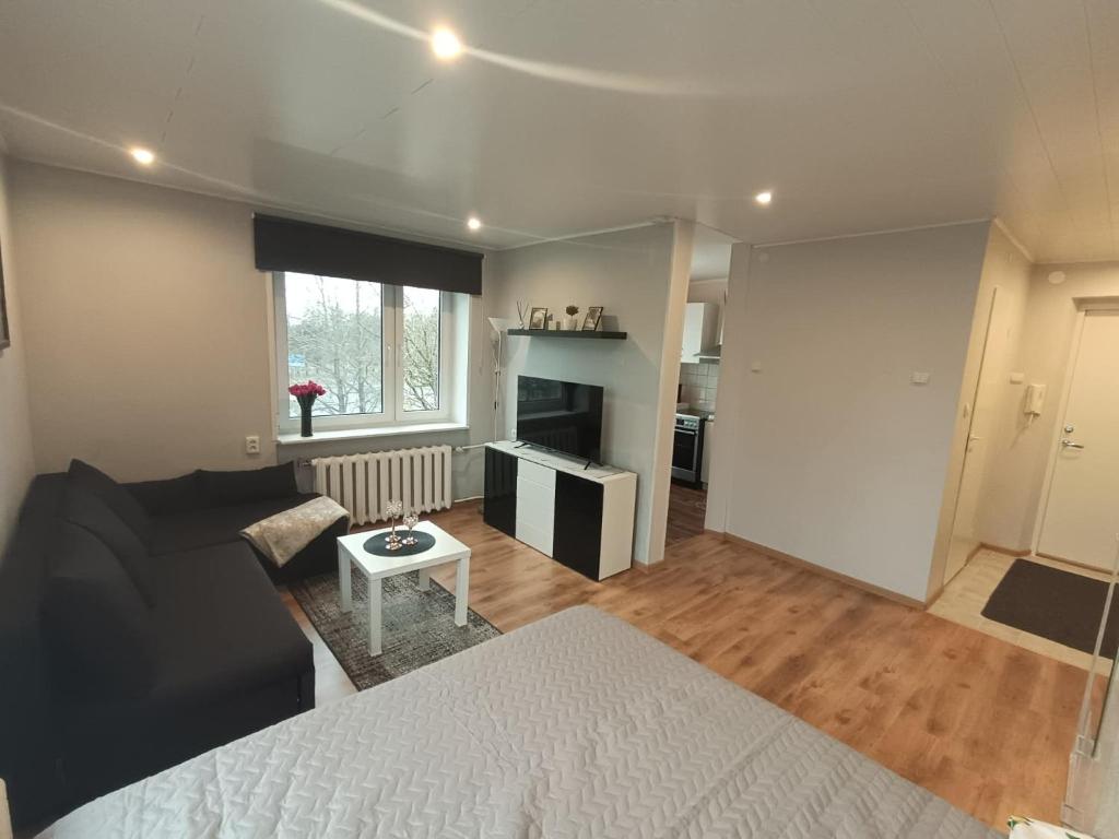 a bedroom with a bed and a living room at Central Haapsalu Apartment in Haapsalu
