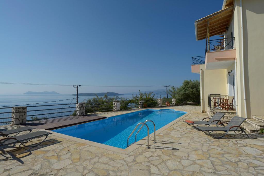 a villa with a swimming pool next to a building at Eleonora Villa in Évyiros