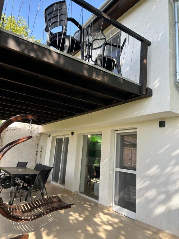 a balcony with a table and chairs on a house at Sun&Fun Vendégház in Balatonakarattya