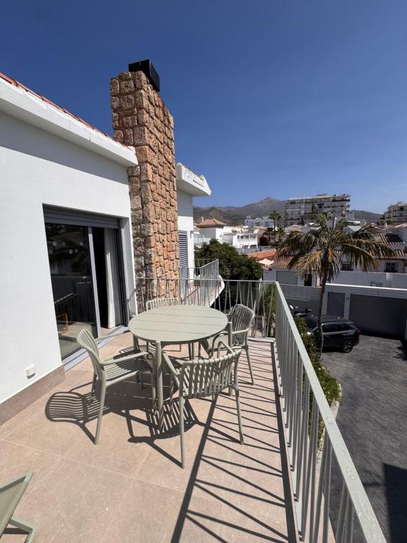 a patio with a table and chairs on a balcony at Terraza Montaña in Nerja