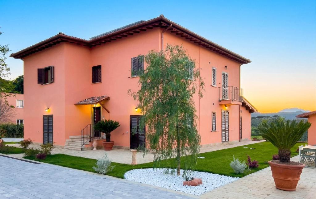 a pink house with a tree in front of it at Casale Saporito in Montopoli in Sabina