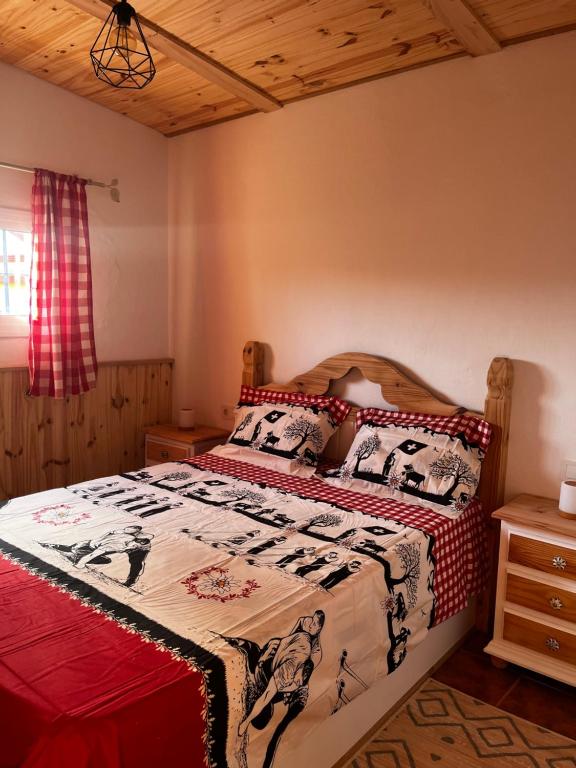 a bedroom with a bed with a quilt on it at Chalet Suizo in Arcos de la Frontera