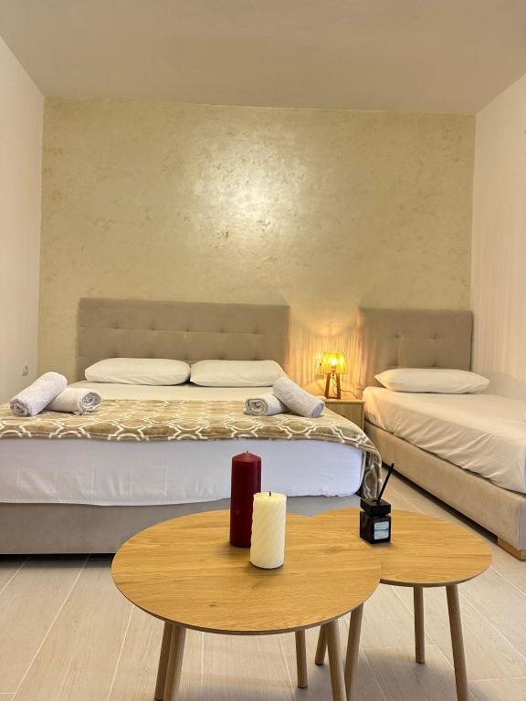 a bedroom with two beds and a wooden table at Villa Adi Saranda in Sarandë