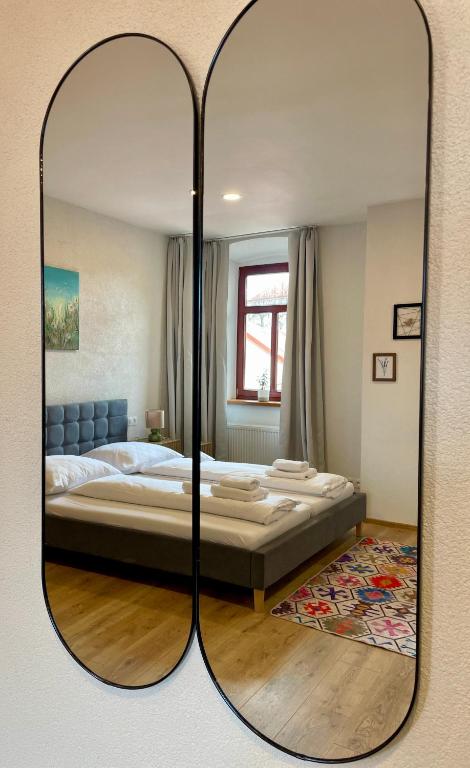 a bedroom with a large bed and a mirror at Alipoint Apartments in Spišské Podhradie
