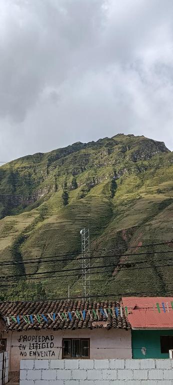 a hill behind a building with a mountain in the background at La Salvaje Bazar Mágico in Yucay