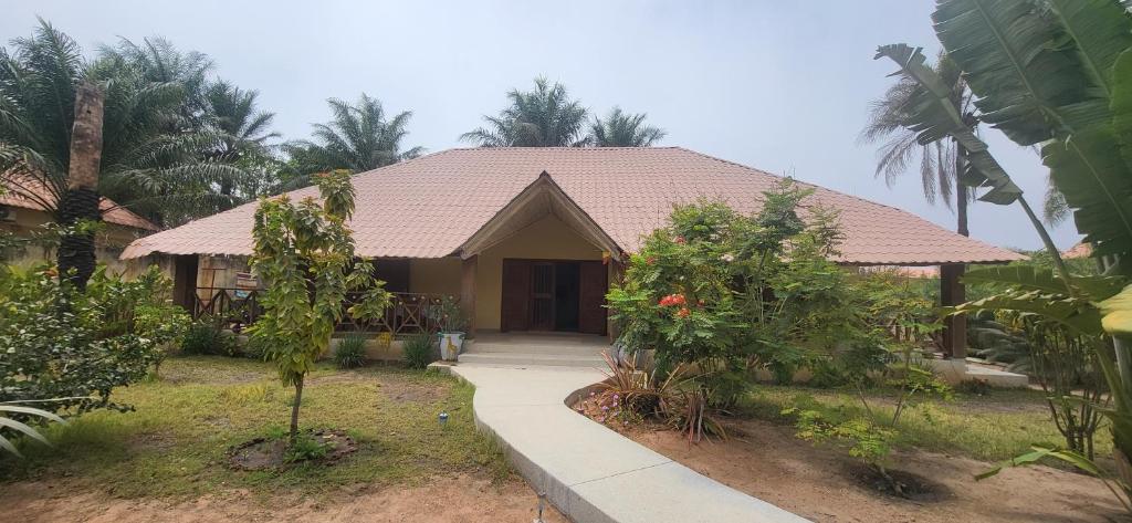 a house with a walkway in front of it at Belle maison dans résidence avec piscine in Cap Skirring