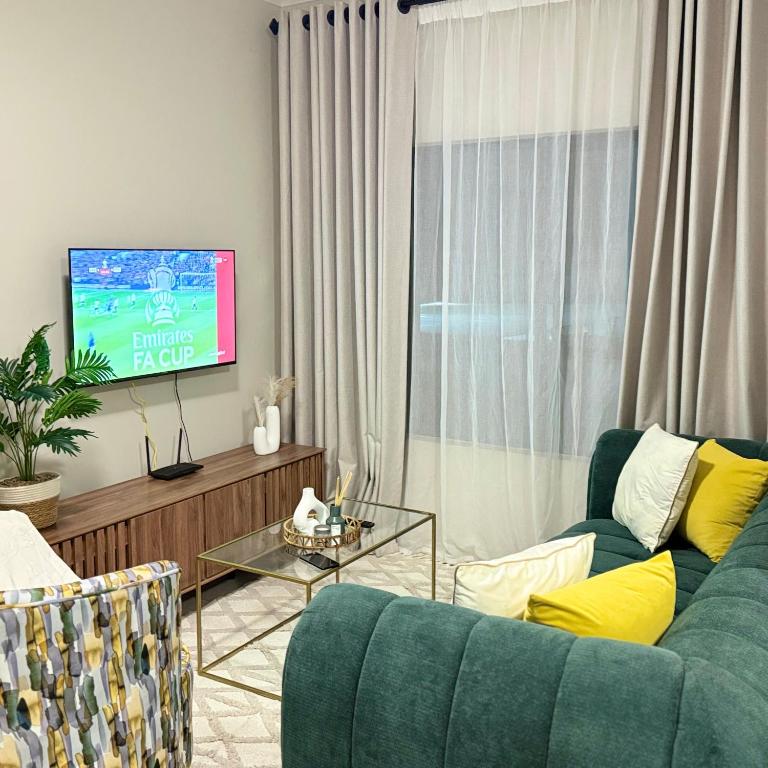 a living room with a green couch and a tv at Kurhula nest in Midrand