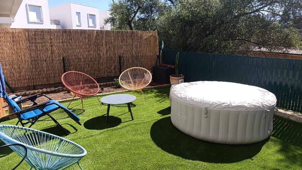 a group of chairs and a large tub in a yard at Maison t3 duplex avec jacuzzi in Bastelicaccia
