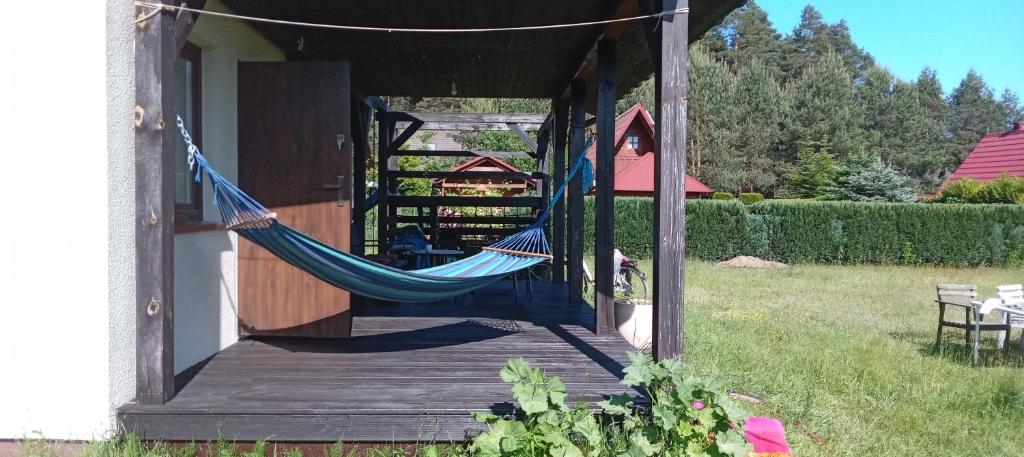 a hammock on a porch of a house at Dom Leśny in Wachów
