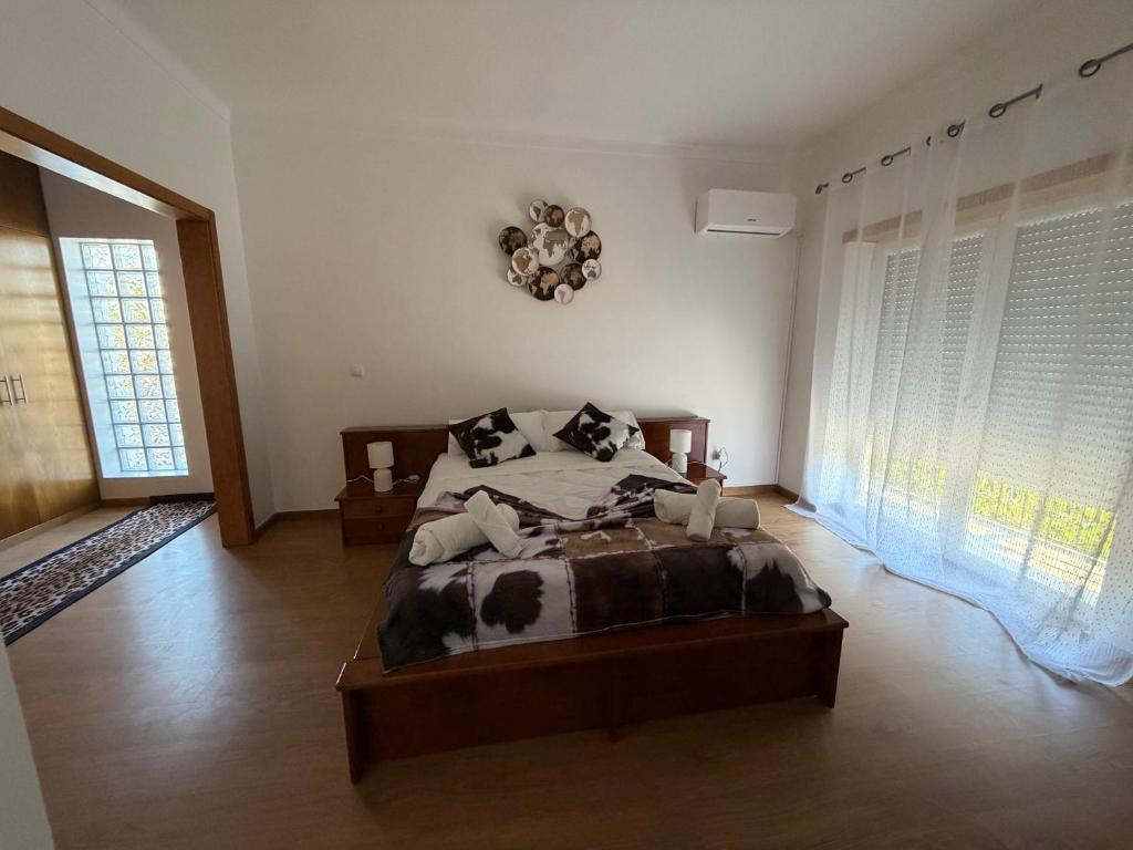 a bedroom with a cow bed in a room with windows at Casa da Tininha in Alcobaça