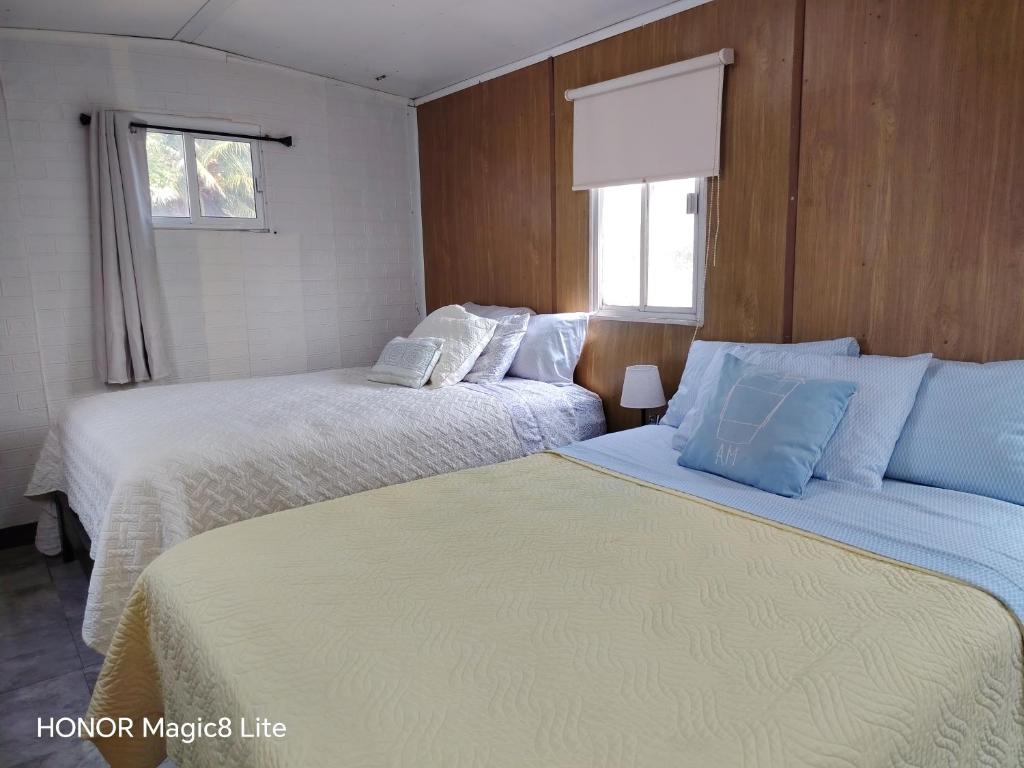 a bedroom with two beds with white and blue pillows at Quinta Aroma Zempoala in Zempoala