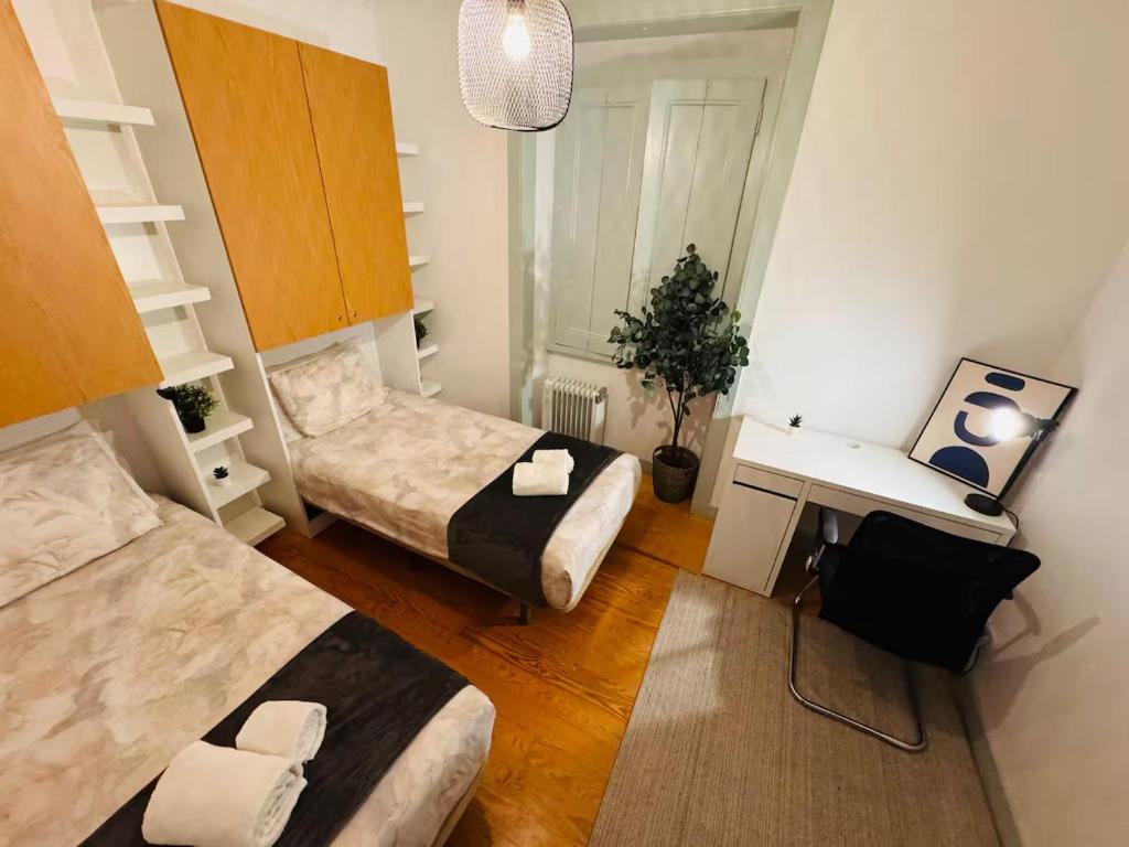 a small room with two beds and a desk at Lisboa Hostel in Lisbon