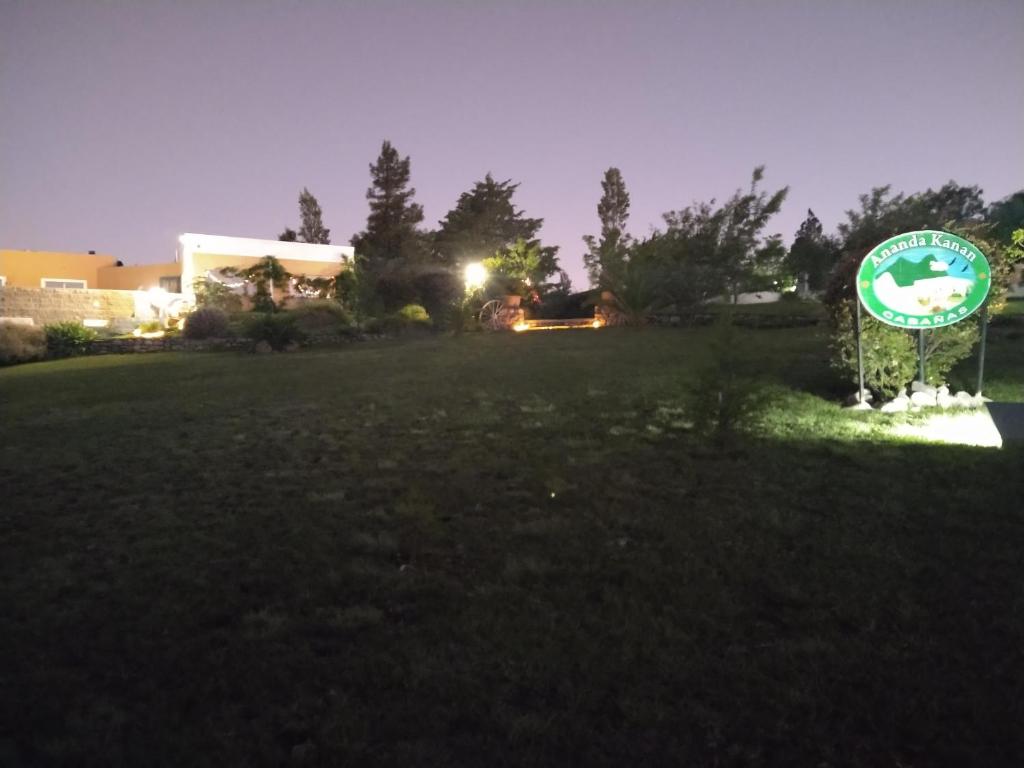 a sign in the middle of a field at night at Cabañas ANANDA KANAN in Villa Giardino