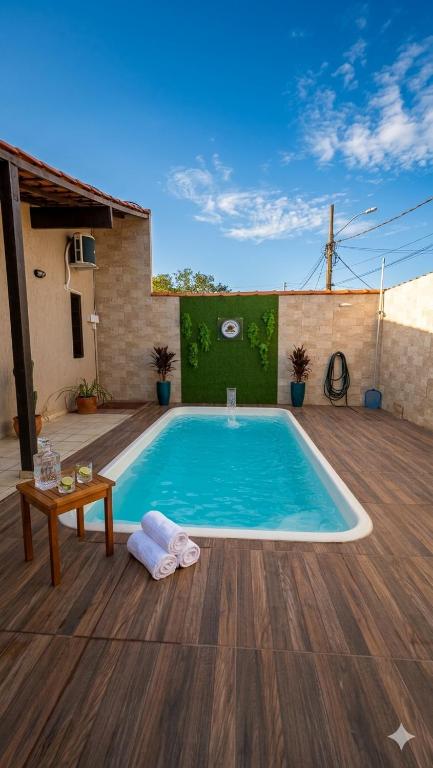 a swimming pool on a patio with a wooden deck at Casarão do Mar in Cabo Frio