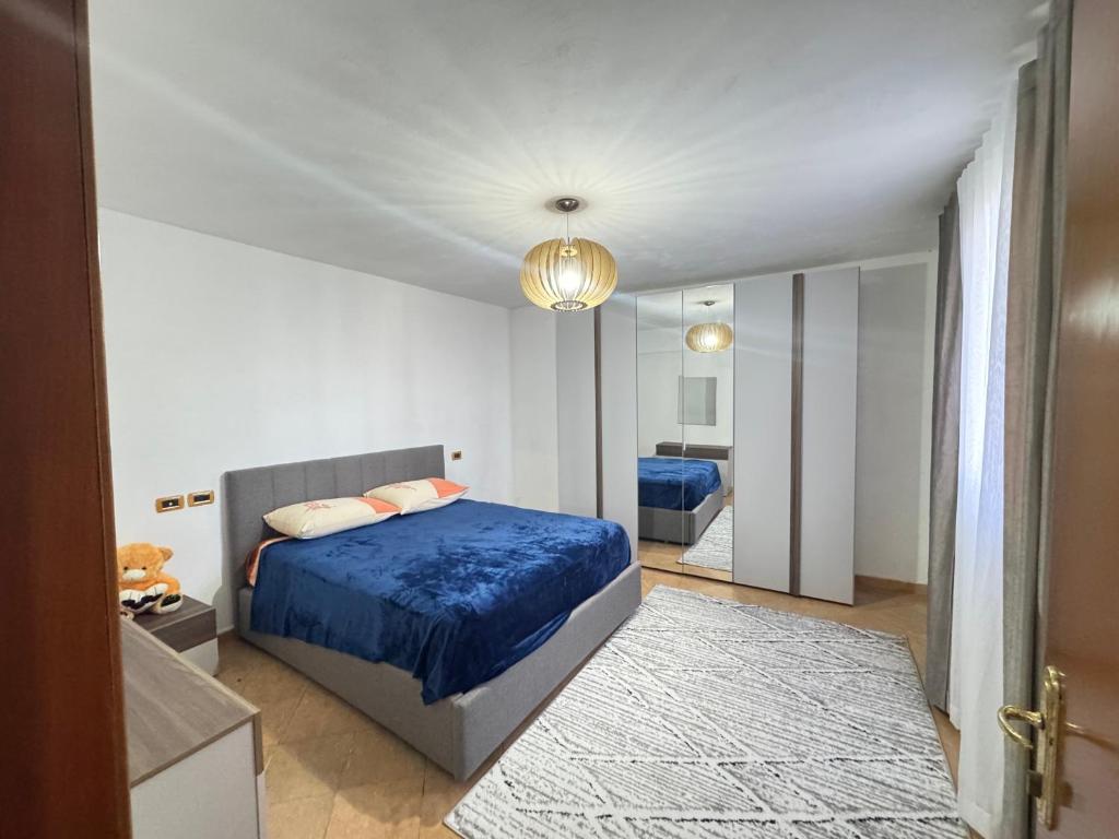 a bedroom with a blue bed and a mirror at Kapllani Guest House in Durrës