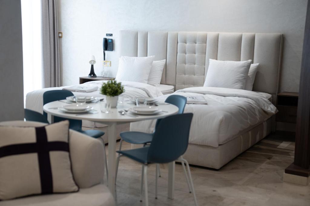 a bedroom with a bed and a table and chairs at Suites Nador in Nador