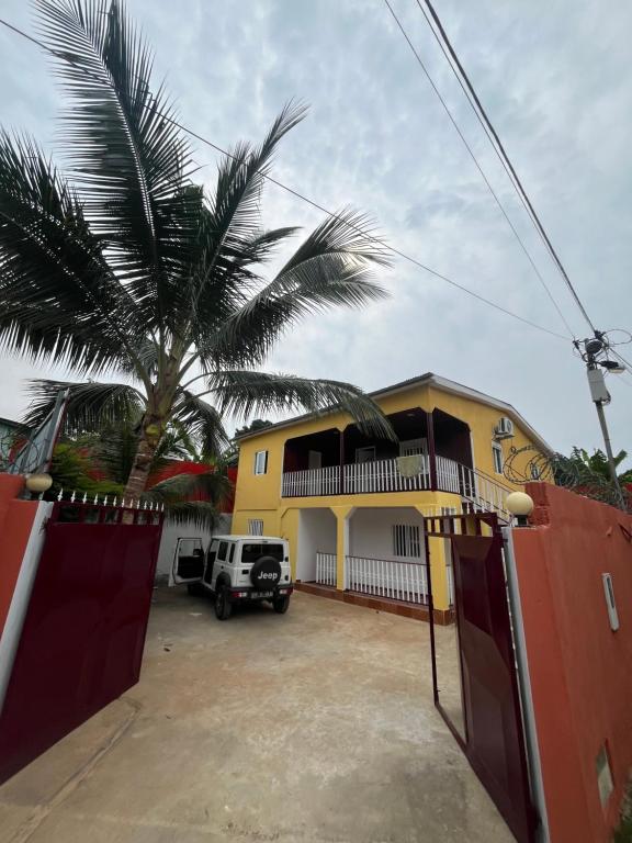 a yellow house with a palm tree in front of it at Holiday Home T3 to T6 on suite in Amparo II