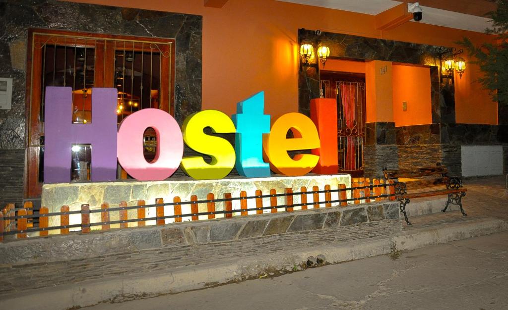 a sign on a building with a bench in front at Hostel Copacabana La Quiaca in La Quiaca