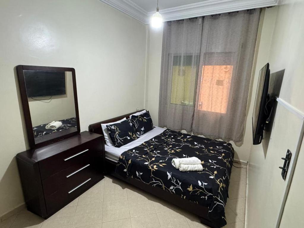 a small bedroom with a bed and a mirror at Apparemment Noucer in Derroua