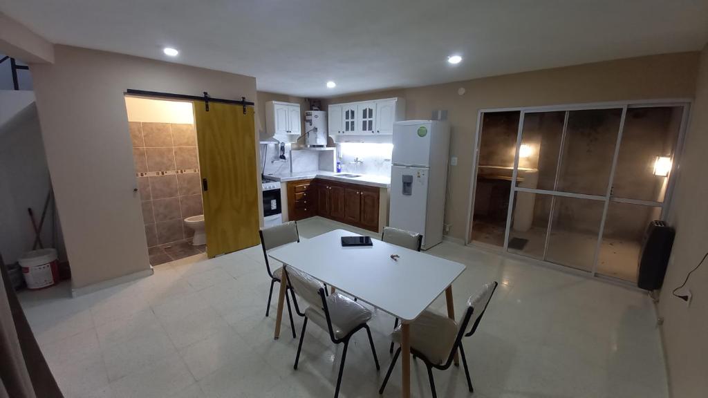 a kitchen with a table and chairs and a refrigerator at Alojamiento Hugo in Río Segundo
