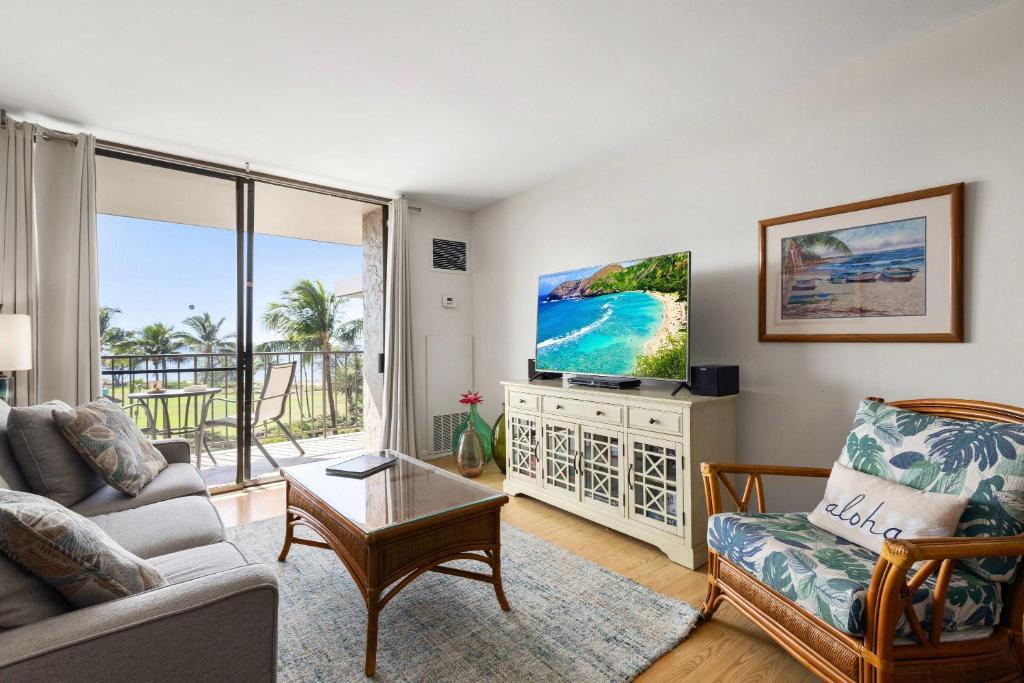 a living room with a couch and a tv at Penthouse Oceanview Vistas in Kihei